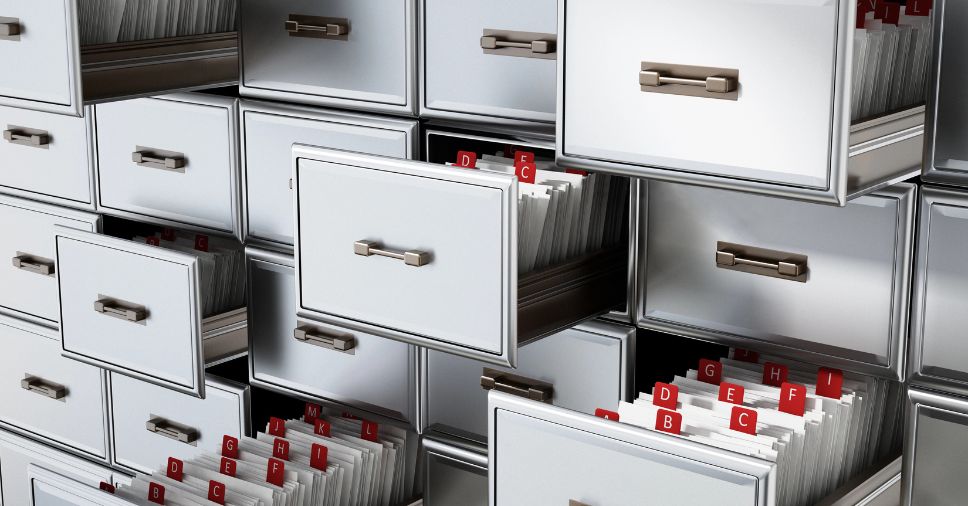 Gavetas e pastas organizando documentos. Como funciona a gestão de documentos armazenados?